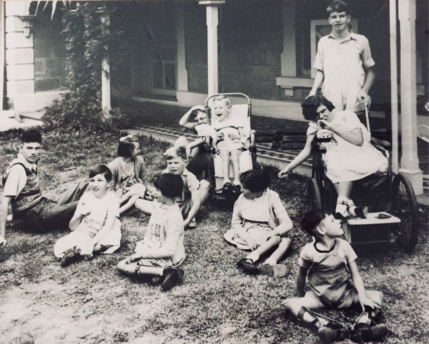 children sitting outside the home