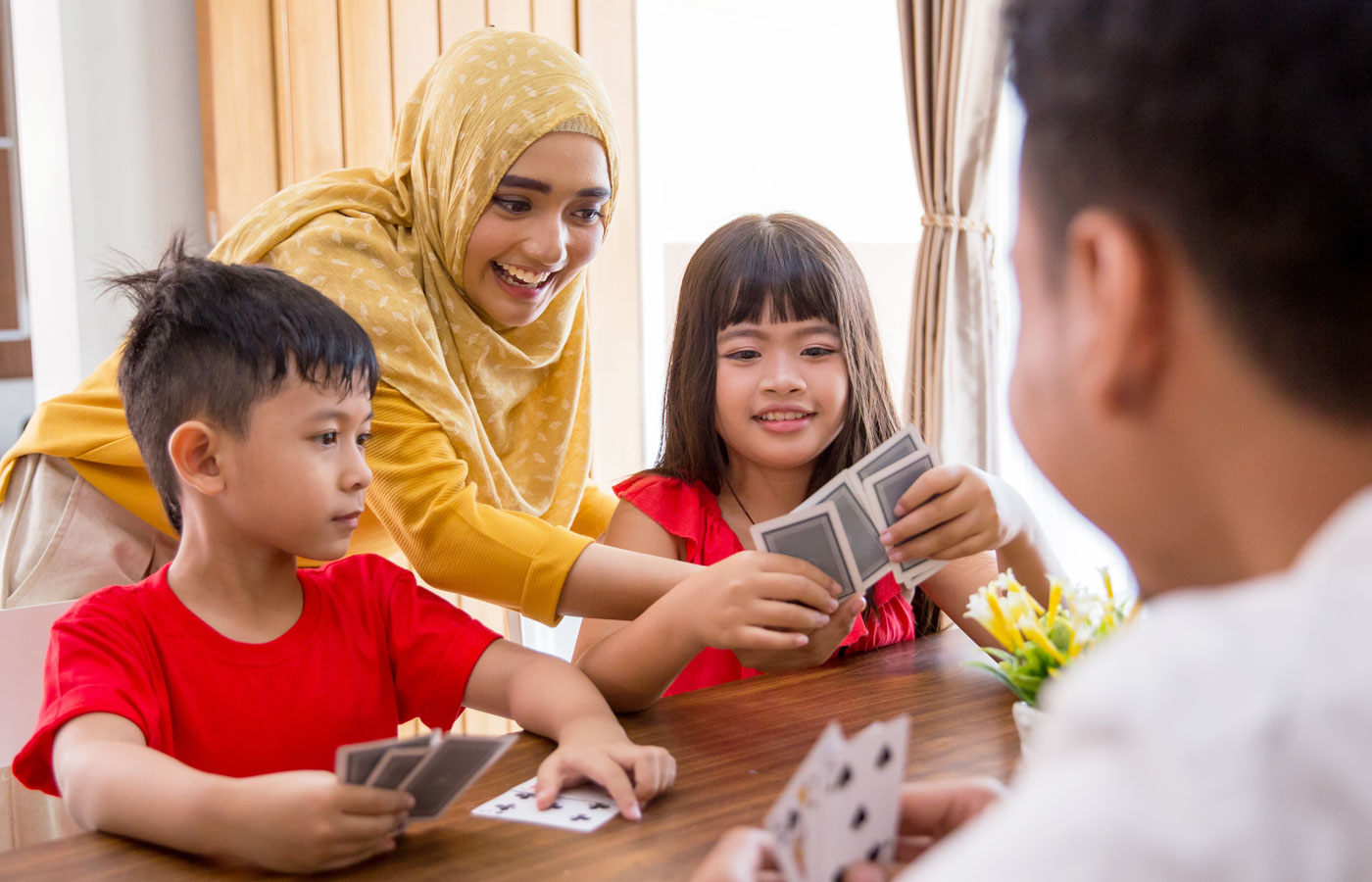 Mother and Father with Young Children playing card games